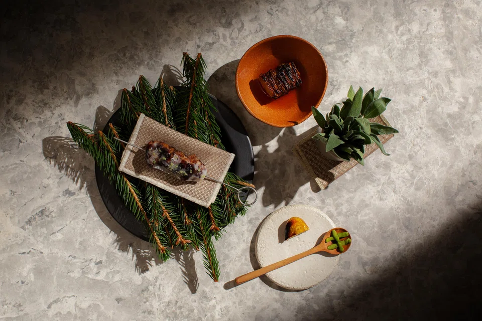 Barbecued lamb saddle with a pine nut and chestnut pesto draped with wild boar lardo, and quince broth.