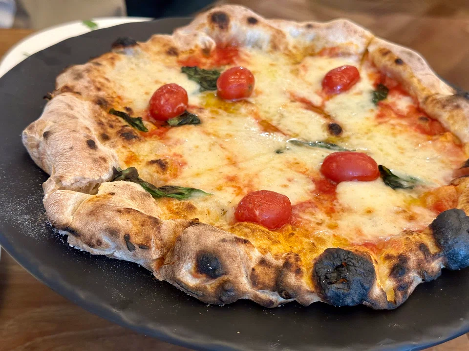 PST's Tamaki pizza features mozzarella and cherry tomatoes.