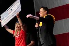 SpaceX and Tesla founder Elon Musk awards Kristine Fishell with a US$1 million check during the town hall at the Roxain Theatre in Pittsburgh, Pennsylvania, Oct 20, 2024. 
