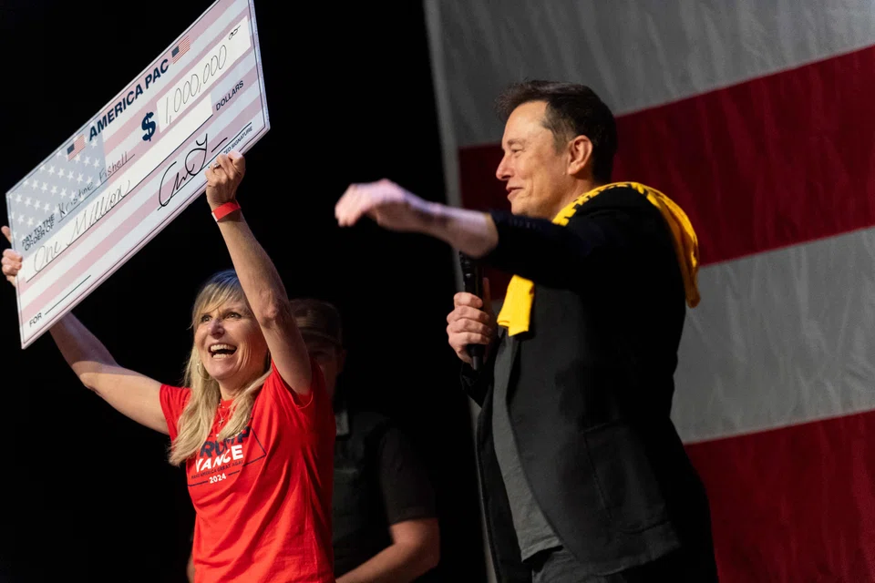 SpaceX and Tesla founder Elon Musk awards Kristine Fishell with a US$1 million check during the town hall at the Roxain Theatre in Pittsburgh, Pennsylvania, Oct 20, 2024. 