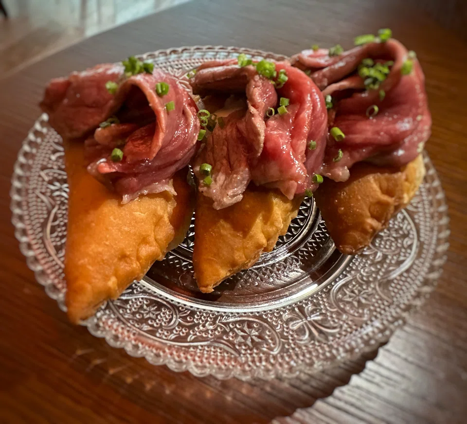 Empanadas are warm and flaky, topped with tender wagyu.