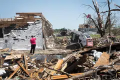 Victoria Turner stands by the remains of her home which was lifted off its foundation and moved about 9 m while she sheltered in the basement during Tuesday's destructive tornado on May 23, 2024 in Greenfield, Iowa. The storm was responsible for several deaths in the small community.  