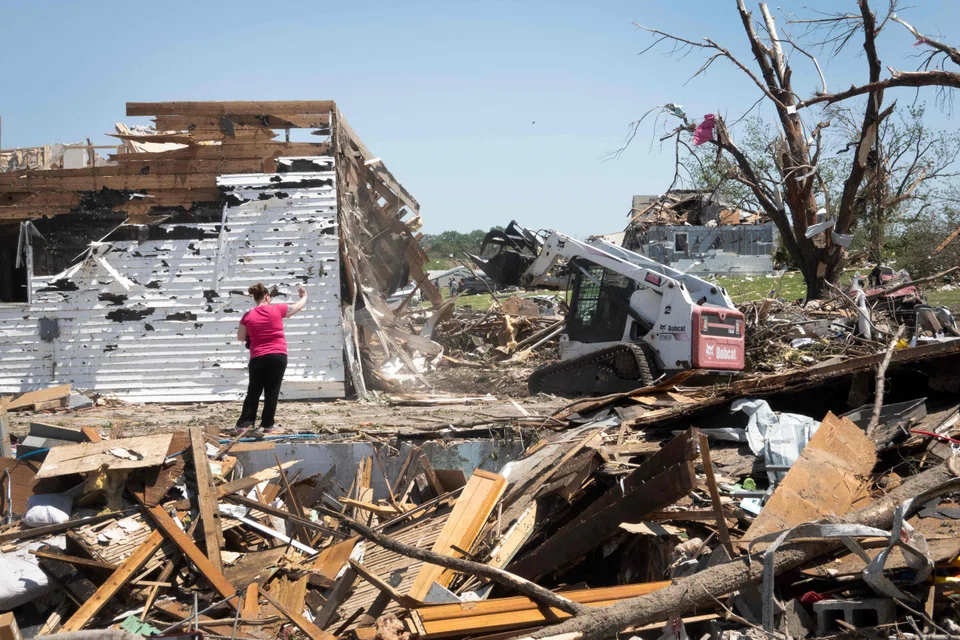 Victoria Turner stands by the remains of her home which was lifted off its foundation and moved about 9 m while she sheltered in the basement during Tuesday's destructive tornado on May 23, 2024 in Greenfield, Iowa. The storm was responsible for several deaths in the small community.  