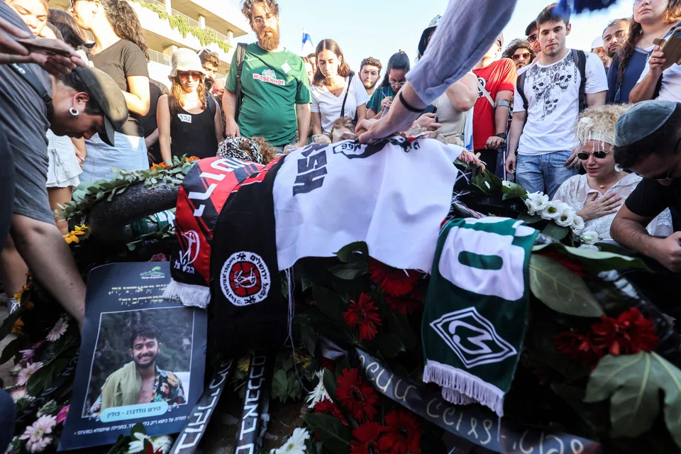 Mourners gather by the grave of killed US-Israeli hostage Hersh Goldberg-Polin whose body was recovered with five other hostages in Gaza, during the funeral at Givat Shaul cemetery in Jerusalem, Israel on Sept 2, 2024. The six were among 251 hostages seized during Hamas's Oct 7 attack that triggered the ongoing war between Israel and Hamas. 
