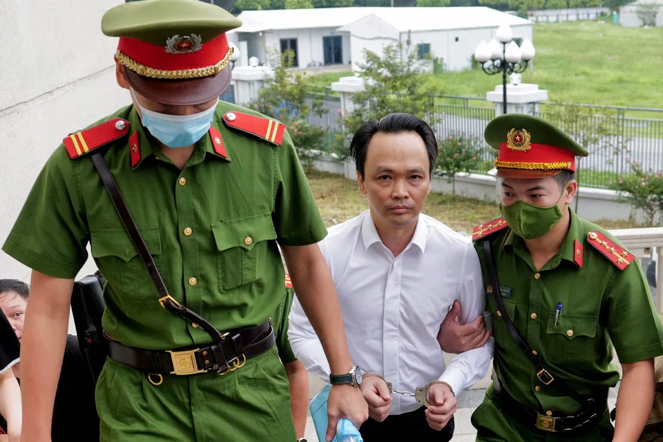 Chairman of FLC group Trinh Van Quyet (centre) is escorted by policemen to a court for his trial on fraud charges in Hanoi, Vietnam, July 22, 2024. 