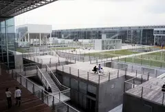 Saitama Prefectural University, completed in 1999, features nine transparent buildings connected by terraces, allowing views from one classroom to another. 