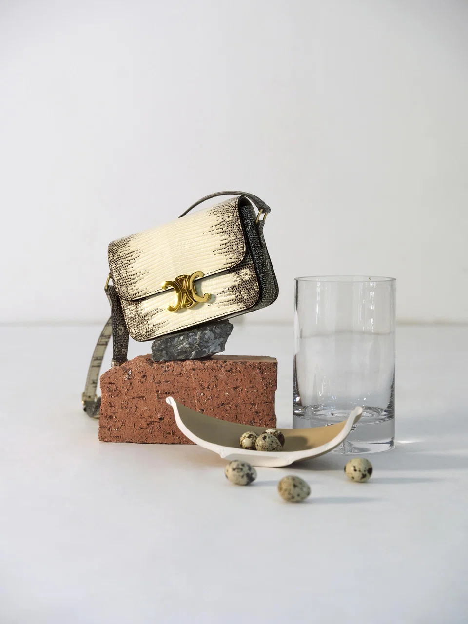 The Teen Triomphe in lizard leather fuses the bag's clean lines with the hide's natural gradient; the white middle perfectly frames the house’s signature Triomphe closure.