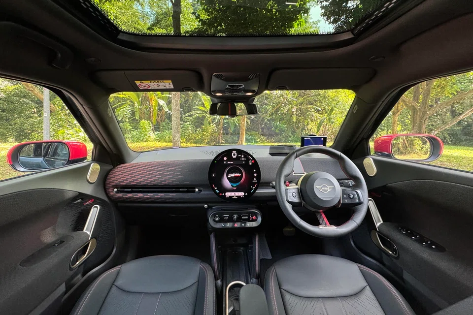The cabin offers typical Mini brio, with knitted fabrics, toggle switches and an enormous circular OLED touchscreen. 

