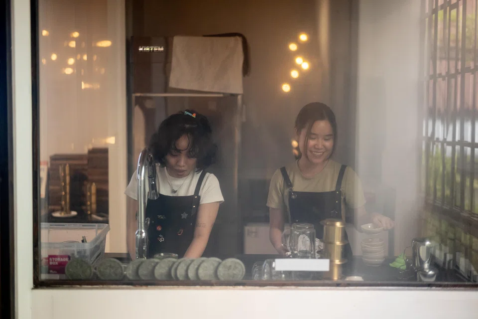 Employees cleaning dishes at Lacaph, a coffeehouse in District 1, just off Rach Ben Nghe, the slim urban canal that snakes through Ho Chi Minh City, Vietnam.
