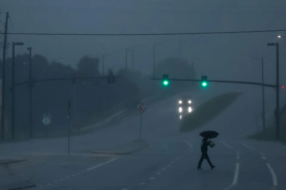 A man walks down an avenue as Hurricane Milton approaches, Orlando, Florida, Oct 9, 2024.  