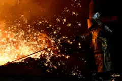 A steel worker stands amid sparks of raw iron coming from a blast furnace at a ThyssenKrupp steel factory in Duisburg, Germany, Nov 5, 2025. 