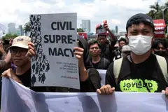Indonesian student activists carry a banner and placards during a protest against the revision of the country's military law in front of the Parliament building in Jakarta.