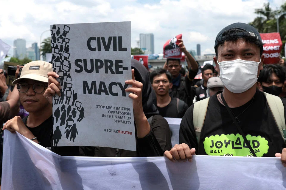 Indonesian student activists carry a banner and placards during a protest against the revision of the country's military law in front of the Parliament building in Jakarta.