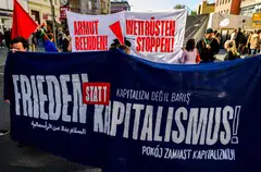 People hold a banner which reads "Peace not Capitalism!" during an anti-capitalism march in Berlin on Apr 30, the eve of May Day protests in the German capital.