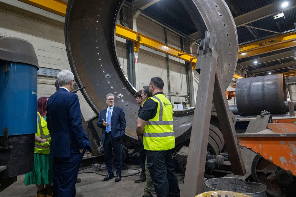 Britain's Prime Minister Keir Starmer (centre) at a factory that makes renewable-energy components in England, in July.