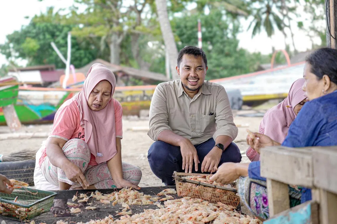 Amartha CEO Andi Taufan with Fitriawati (left), salted fish seller, in Koto Tangah, Padang, West Sumatera.

