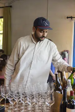 Arjav Ezekiel prepares wine at Birdie's, his restaurant in Austin, Texas on Aug 6, 2024. Ezekiel rose through the restaurant ranks, becoming a sommelier and opening Birdie's but few knew of his past as an undocumented immigrant. 