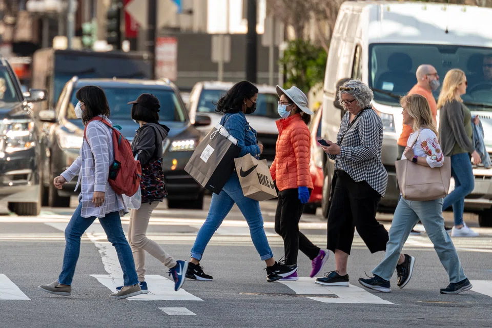 A pedestrian carries shopping bags in San Francisco. For the first half of the year, consumers were traumatised by an upward spiral in prices with no end in sight. People stockpiled goods and demanded higher wages, which hastened inflation. Now there are signs that the pattern is going into reverse.