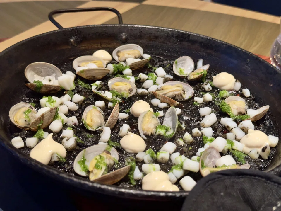 Squid ink paella is chock full of baby clams and squid.