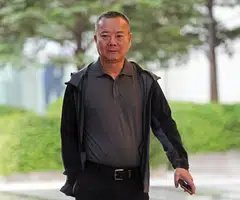 Chinese national Zhan Guotuan admits to authorising the purchase of landed properties in East Coast Road. 