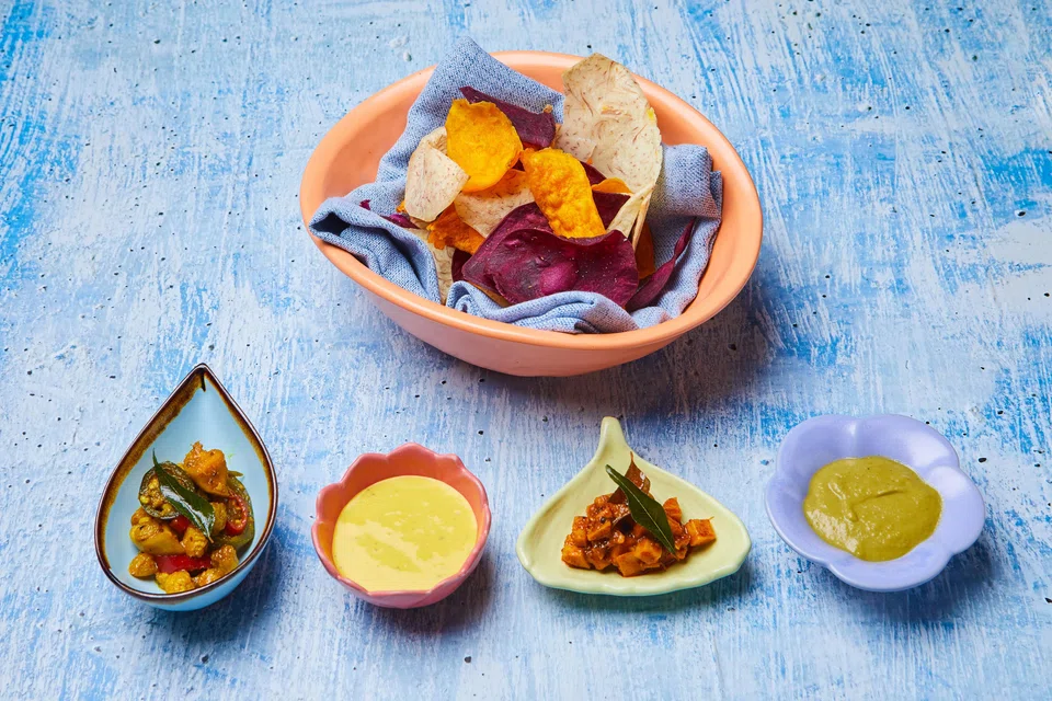 Mixed chips are served with guacamole and dips.