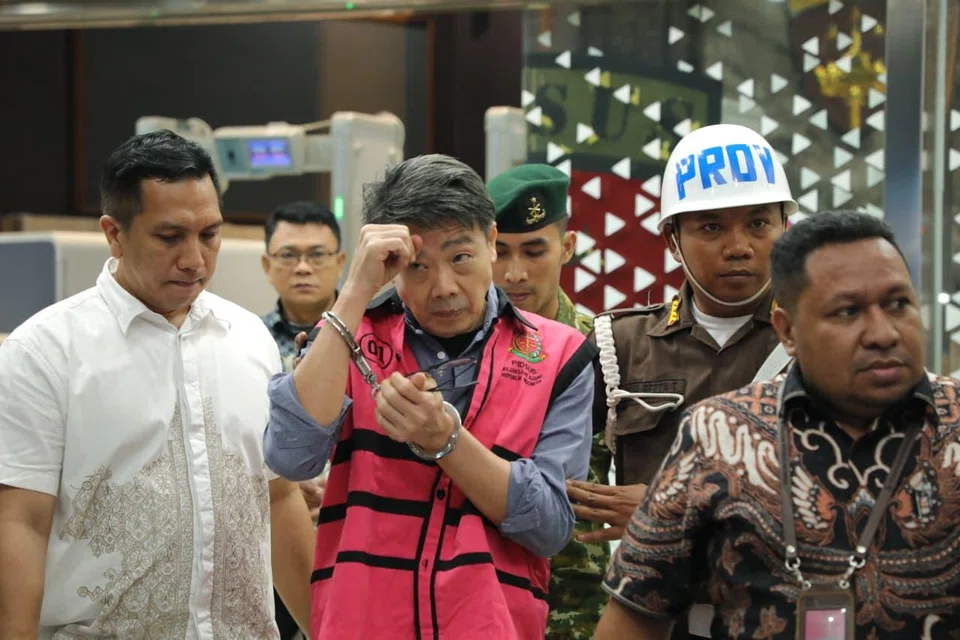 Samin Tan (in pink vest) arriving for questioning at the Indonesian Attorney-General's Office in Jakarta. He is one of Indonesia’s wealthiest individuals, with a net worth estimated at about US$940 million. 