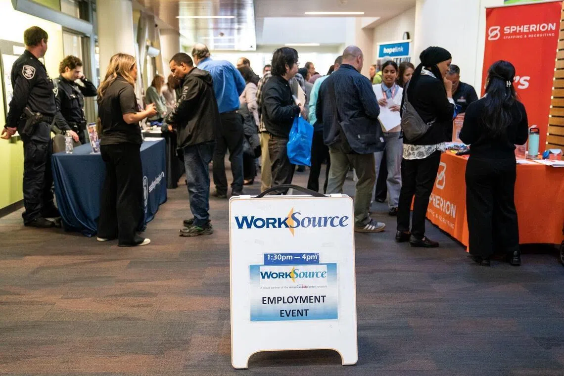 Jobseekers speak with recruiters at a career fair in Seattle, Washington, Feb 10, 2026. 