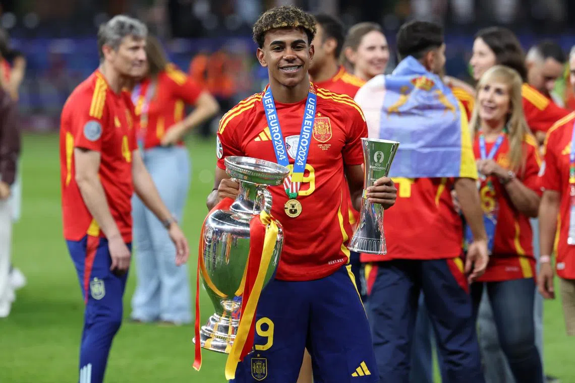 Lamine Yamal of Spain celebrates with the Euro 2024 trophy and the Young player of the tournament trophy after the 2-1 victory over England in Berlin.