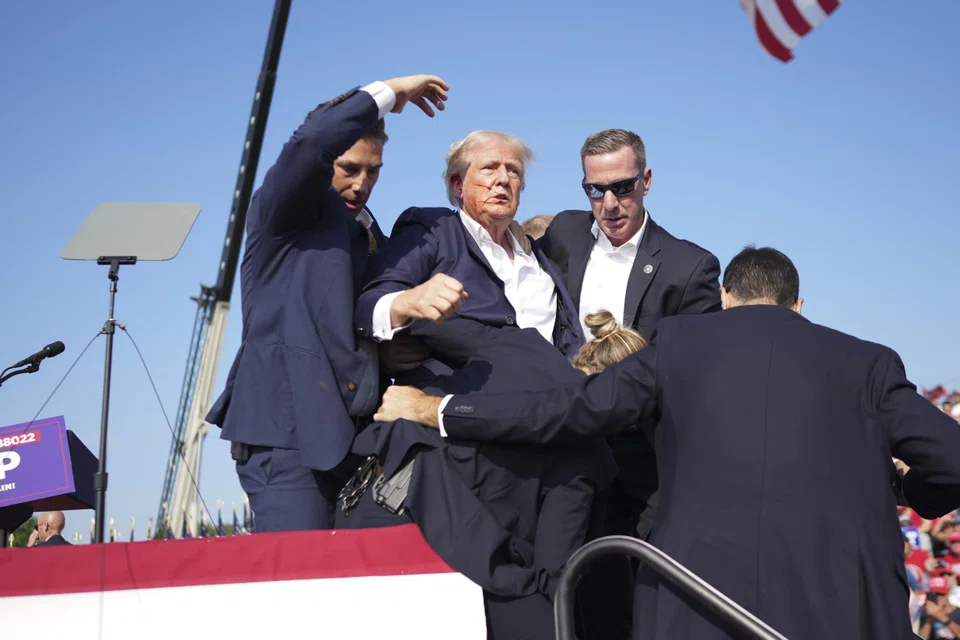 Former president Donald Trump is rushed offstage by Secret Service agents at a campaign rally in Butler, Pennsylvania, US, Jul 13, 2024. 