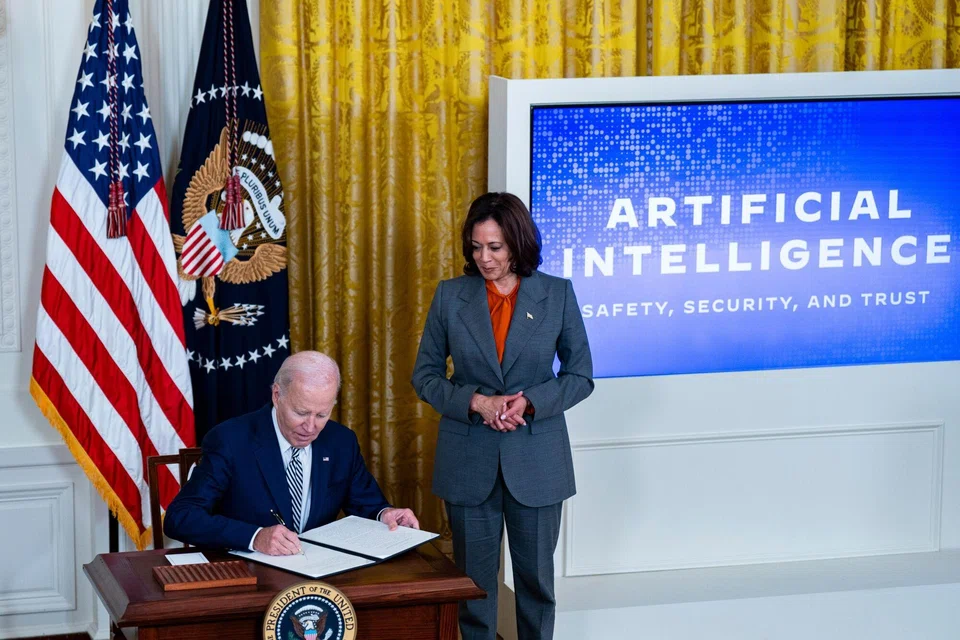 US President Joe Biden signs an executive order with US Vice-President Kamala Harris (right) during an event in the East Room of the White House in Washington, DC, on Oct 30, 2023. 