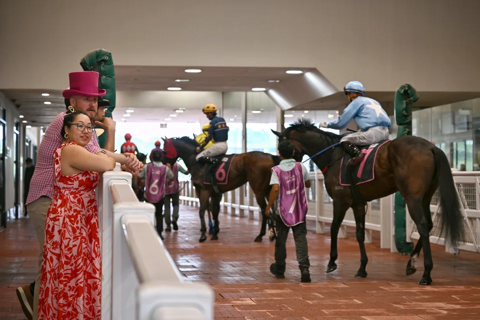 Punters catching a glimpse of the race horses at the Singapore Derby 2024 race meeting at Singapore Turf Club on Sunday (Jul 21). 