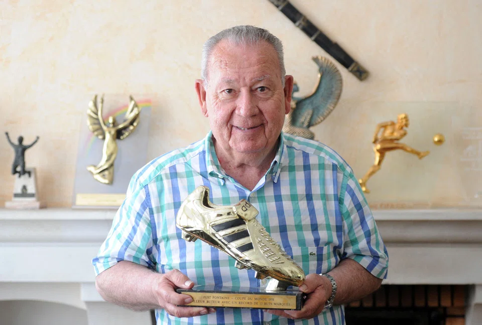 Former French international football player Just Fontaine poses with a trophy for the 1958 football World Cup top-scoring record at his home in Toulouse, southwestern France on July 18, 2013.