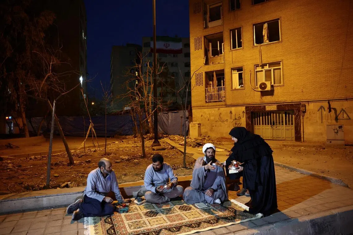 Iranian women deliver iftar meal packages to the volunteer team, that helps people affected clean and restore homes after strikes in Teheran on Mar 18.