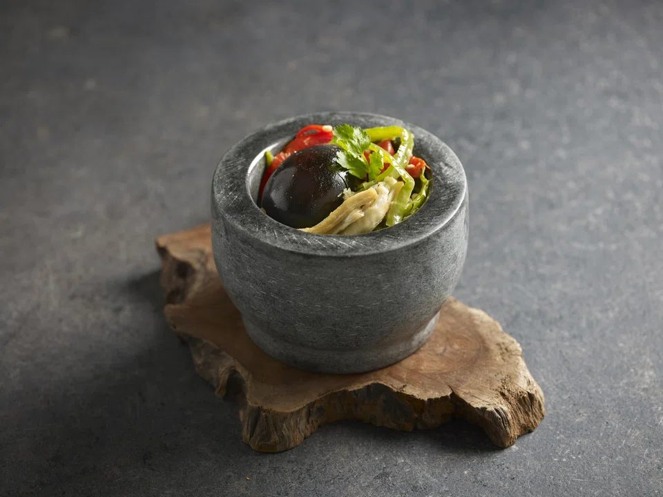 Century eggs liven up a mixture of green chillis and eggplant.