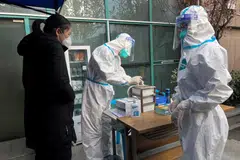 A medical worker in a protective suit registers information for a patient at the entrance to the fever clinic of the Central Hospital of Wuhan in Wuhan, China, Dec 31, 2022. Covid-19l ikely arose from a Chinese laboratory leak, the US Department of Energy now says according to media.