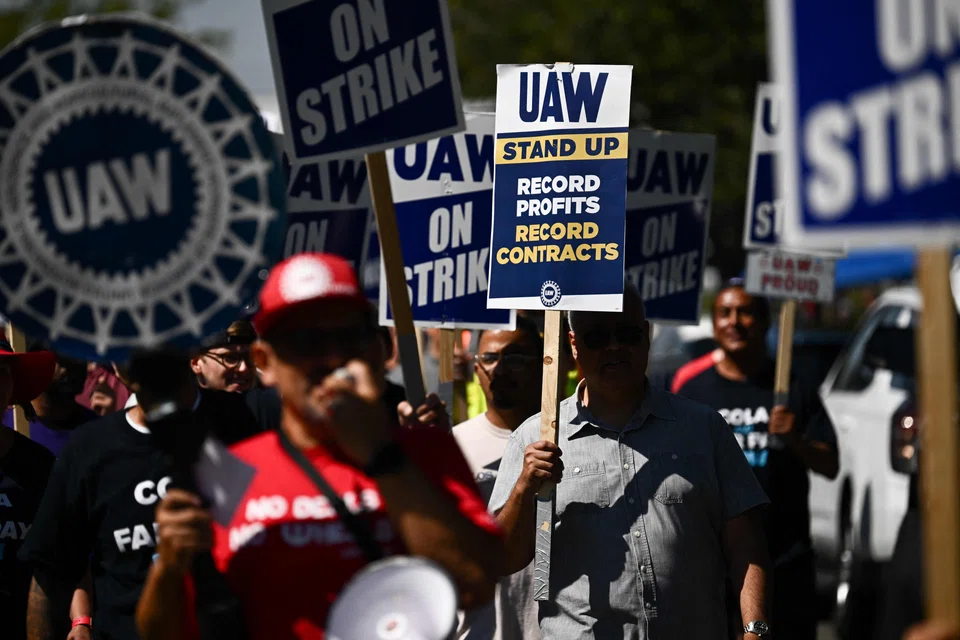Supporters and members of the United Auto Workers union- Local 230 march along a picket line during a strike outside of the Stellantis Chrysler Los Angeles Parts Distribution Centre in Ontario, California, Sept 26, 2023. 