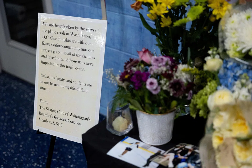 A sign at a memorial for victims Sean Kay, Angela Yang and coach Sasha Kirsanov who were on board American Airlines flight 5342 in Delaware, US, Feb 2, 2025.  