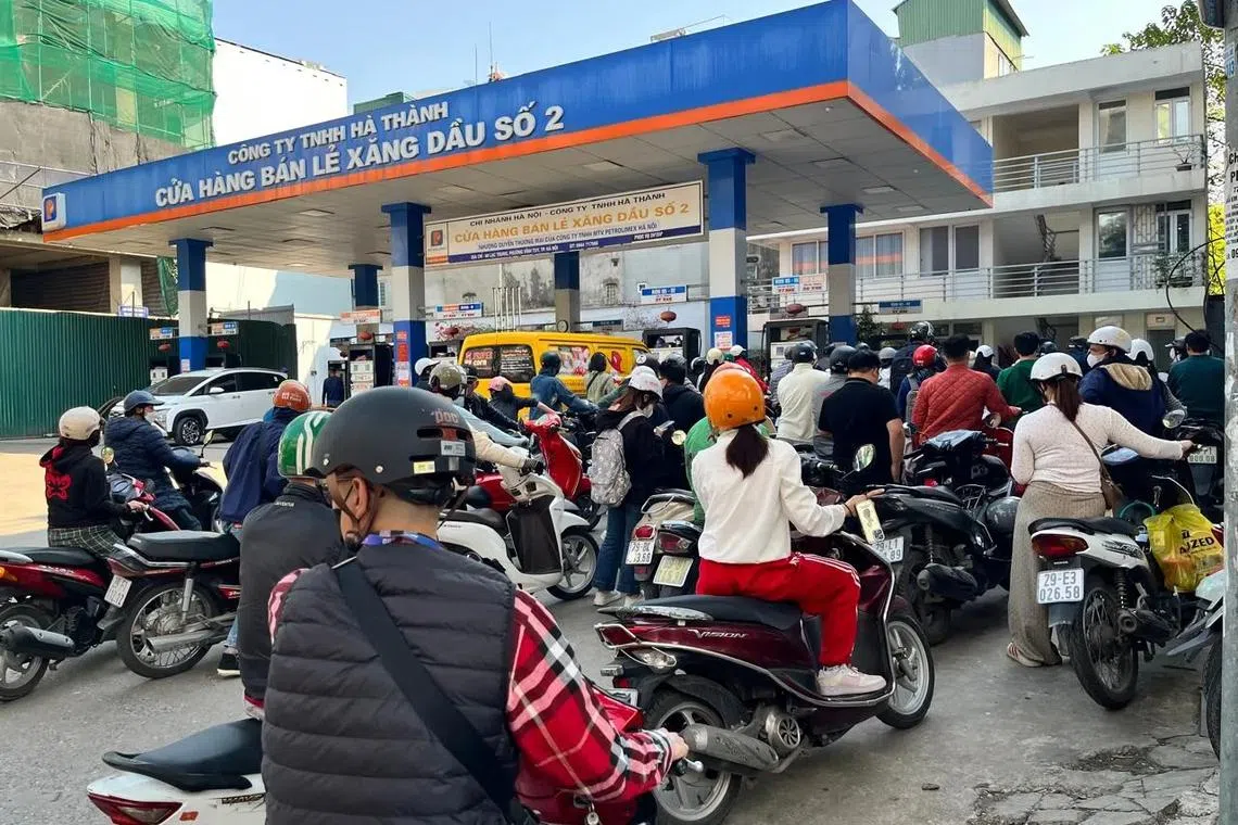 Motorists line up to refuel at a gas station in Hanoi on Mar 10.