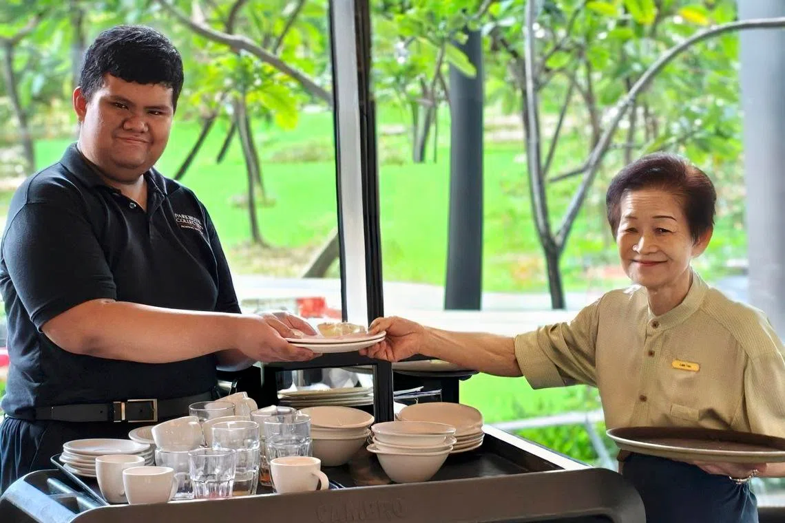 Dave Burgos Abelinde (left), a PWD working in F&B services, often helps mature worker Tan Lian Tee carry heavy things when they work together at ParkRoyal Collection Pickering’s buffet restaurant.