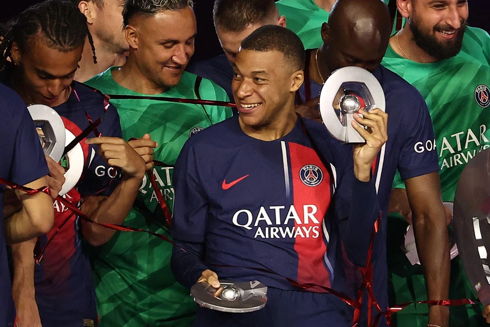 PSG French forward Kylian Mbappe celebrates after winning the French Ligue 1 championship following the match between PSG and Toulouse on May 12, 2024 at the Parc des Princes stadium in Paris, France.