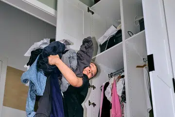 A girl feeling overwhelmed with her clothes