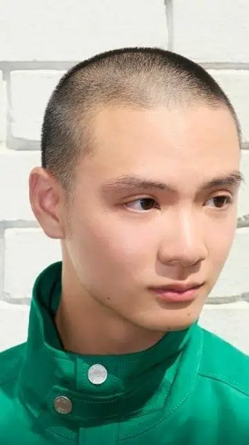  Singaporean creative Leo Cheng, a rising ballet dancer, posing in contemporary streetwear. The image captures movement and fashion in a modern Singaporean architectural courtyard