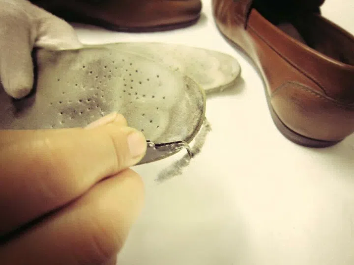 Artisans replacing shoe soles
