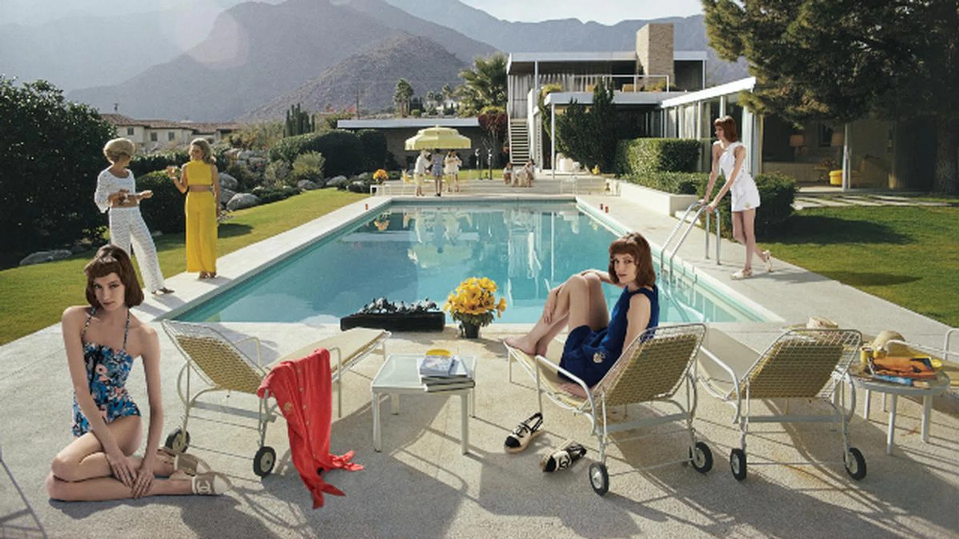 Former fashion model Helen Dzo Dzo Kaptur (in white lace) and Nelda Linsk (in yellow), wife of art dealer Joseph Linsk, at the Kaufmann Desert House in Palm Springs, California, January 1970. The Linsks are the current owners of the house.  (Photo by Slim Aarons/Getty Images)