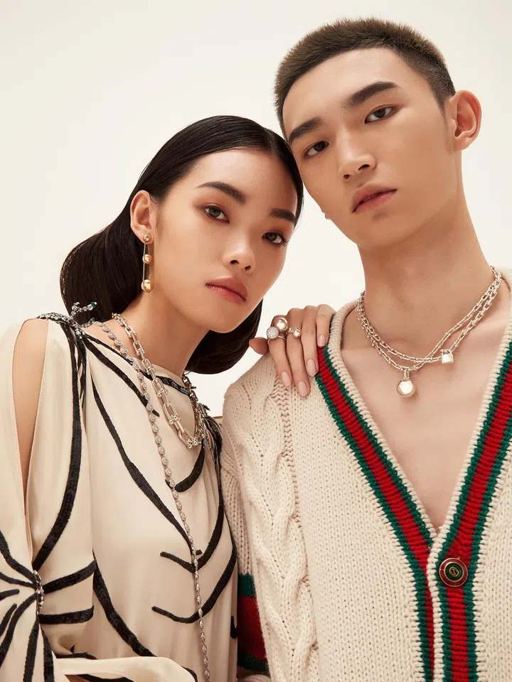 On her: Silk kaftan with crystals, Gucci. Hardwear Triple Drop 18K yellow gold earrings, matching Link sterling silver necklace, Tiffany Circlet platinum necklace with diamonds, (on left hand, from left) Hardwear Ball 18K white gold ring with diamonds, and matching rings in sterling silver, Tiffany & Co. On him: Wool cardigan, Gucci. Hardwear sterling silver wrap necklace, Tiffany & Co. 