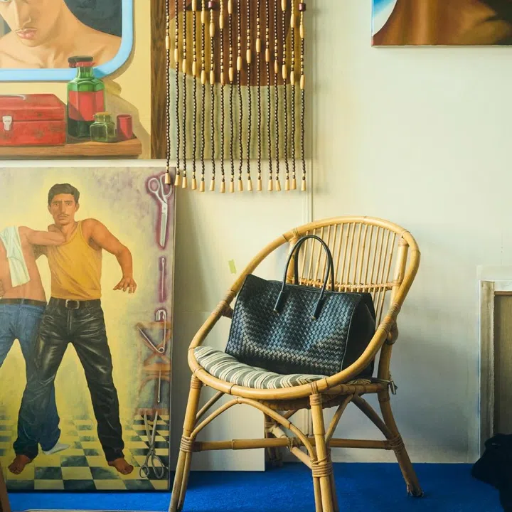Bottega Veneta black Barbara tote bag on a rattan chair in Israfil Ridhwan’s art studio for F ZINE.