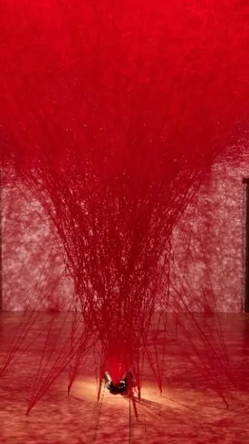 Red thread installation by Japanese artist Chiharu Shiota titled The Network Within at the Flesh and Bones exhibition, ArtScience Museum Singapore.