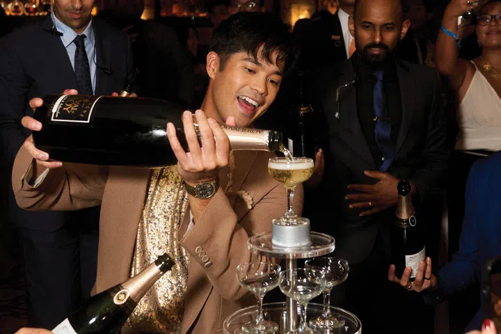 Actor Ross Butler hosts the re-opening party at LAVO Marina Bay Sands in Singapore, celebrating with champagne at the rooftop restaurant