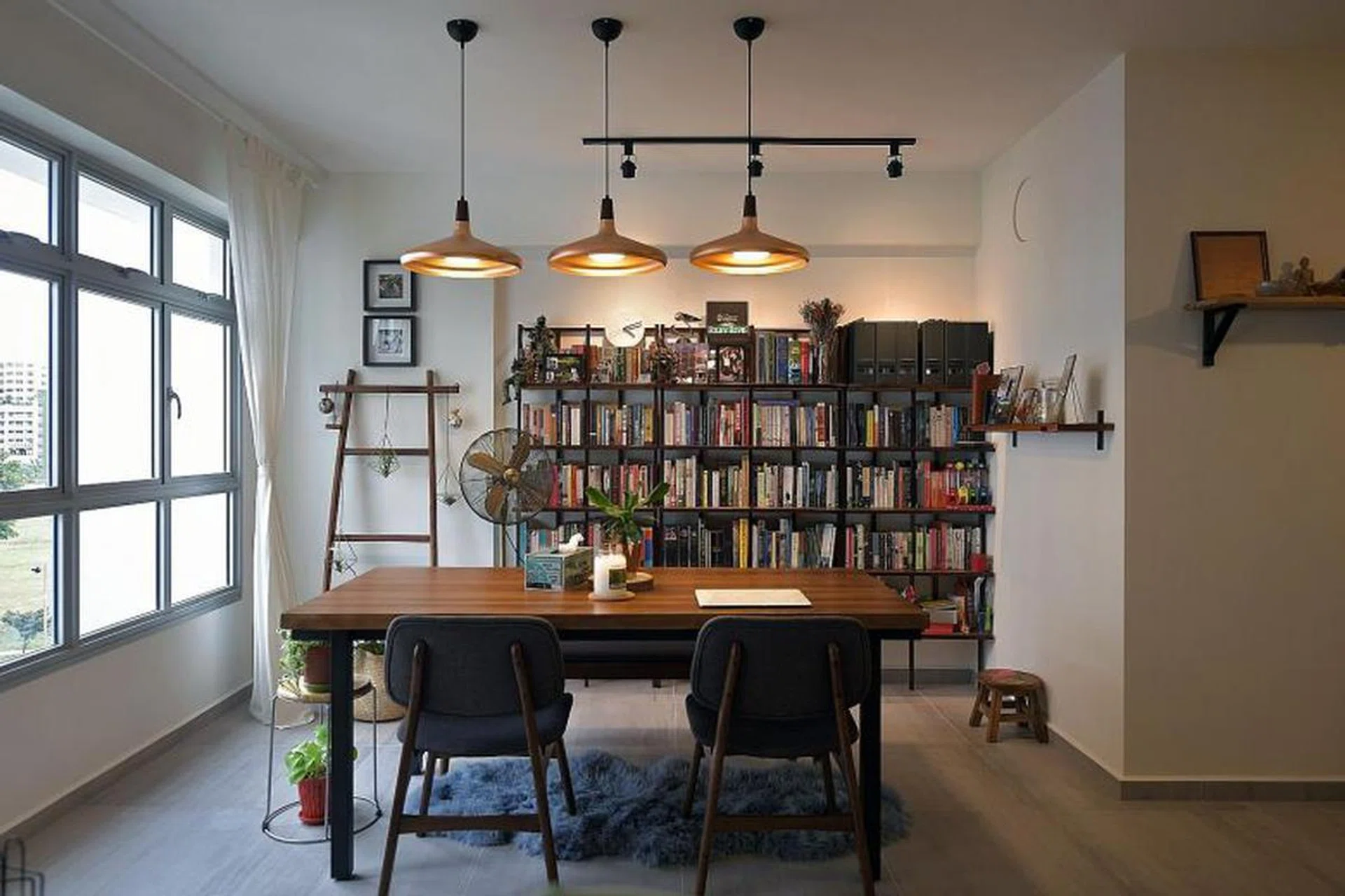The bookshelves behind the dining table in the home of Ms Joy Fang and Mr Daryll Nanayakara are among the online purchases the married couple made. They also added design elements such as a turquoise wall in the living room (above) as the renovation process went on. St Photo: Kua Chee Siong 