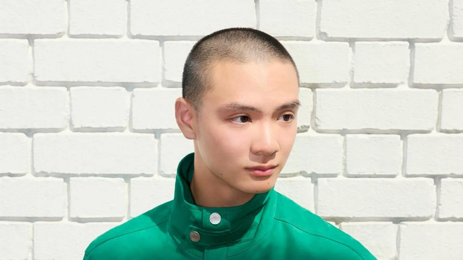  Singaporean creative Leo Cheng, a rising ballet dancer, posing in contemporary streetwear. The image captures movement and fashion in a modern Singaporean architectural courtyard